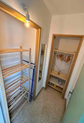 a room with a closet with wooden shelves and a door at Orangers - Bord de mer - Studio cosy 4 personnes in Cagnes-sur-Mer