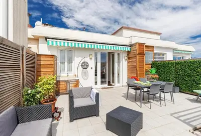 a patio with a table and chairs and a house at Deux pièces terrasse sous les étoiles in Nice