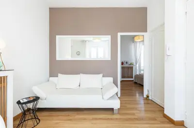 a living room with a white couch in a room at Deux pièces terrasse sous les étoiles in Nice