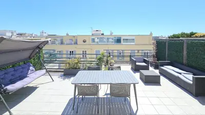 a patio with a table and chairs on a roof at Deux pièces terrasse sous les étoiles in Nice