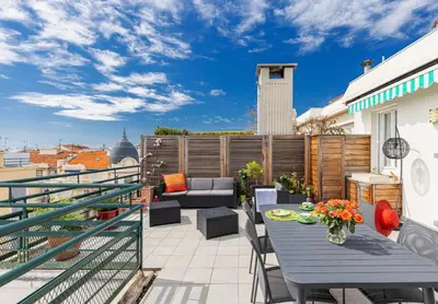 a patio with a table and chairs on a balcony at Deux pièces terrasse sous les étoiles in Nice