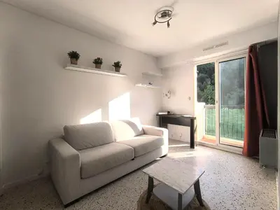 a living room with a white couch and a table at F1 - 8MIN DE LA PLAGE - 5MIN TRAMWAY in Nice
