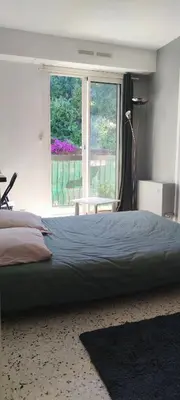 a bedroom with a large bed and a large window at F1 - 8MIN DE LA PLAGE - 5MIN TRAMWAY in Nice