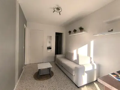 a living room with a white couch and a table at F1 - 8MIN DE LA PLAGE - 5MIN TRAMWAY in Nice