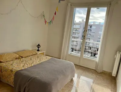 a bedroom with a bed and a large window at Appartement à 50 mètres de la plage in Cagnes-sur-Mer