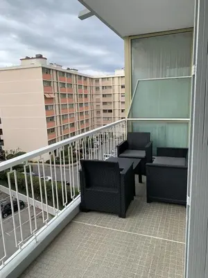 a balcony with chairs and tables on a building at Appartement à 50 mètres de la plage in Cagnes-sur-Mer