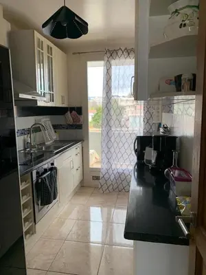 a kitchen with a black counter top and a window at Appartement à 50 mètres de la plage in Cagnes-sur-Mer