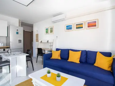 a living room with a blue couch and a table at Apartment Villa Emeraude by Interhome in Cagnes-sur-Mer
