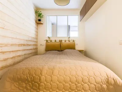 a bedroom with a large bed with a window at Apartment Les Arènes de Cimiez-1 by Interhome in Nice