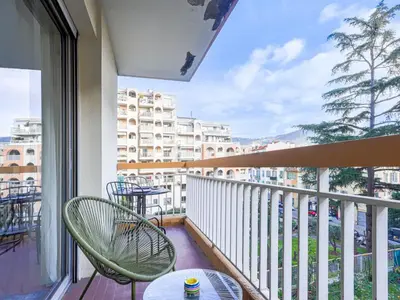 a balcony with a table and chairs and a view of a city at Apartment Les Arènes de Cimiez-1 by Interhome in Nice