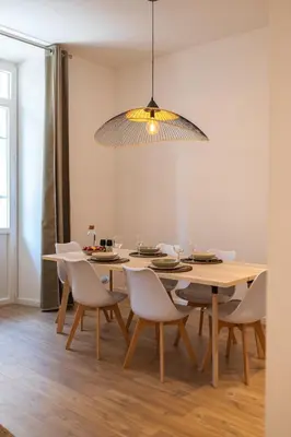 a dining room table with white chairs and a light fixture at Magnifique 2P avec vue sur le port de Nice in Nice