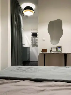 a bedroom with a bed and a table and a lamp at EZE Roc (Monaco) in Èze
