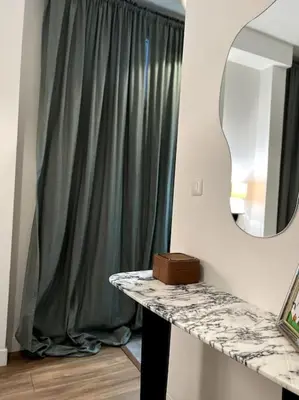 a bathroom with a green shower curtain and a mirror at EZE Roc (Monaco) in Èze