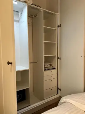 a bedroom with a closet with white cabinets and a bed at EZE Roc (Monaco) in Èze
