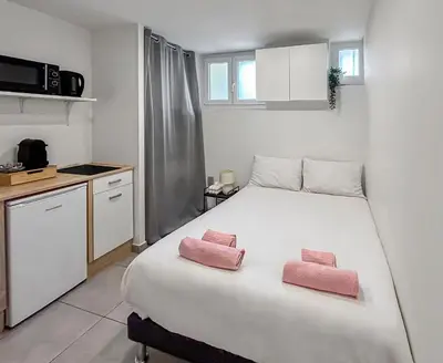 a bedroom with a bed with two pink towels on it at Studio Centre Ville proche TRAM & Port, Wifi Gratuit in Nice