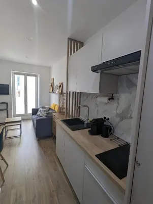 a kitchen with a counter top and a living room at appartement carré d'or in Nice