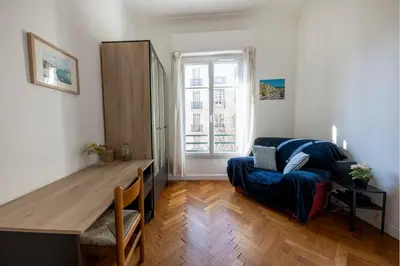 a living room with a blue couch and a table at * Le Provençal * cosy flat 3 min walk from the sea in Nice