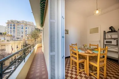 a dining room with a table and chairs on a balcony at * Le Provençal * cosy flat 3 min walk from the sea in Nice