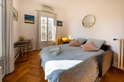 a bedroom with a bed with pink pillows and a mirror at * Le Provençal * cosy flat 3 min walk from the sea in Nice