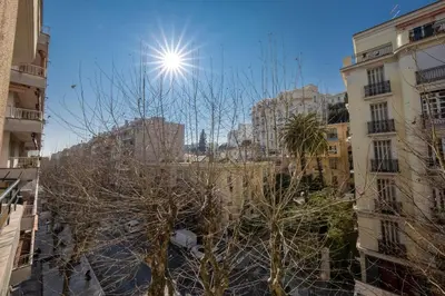 a sun shines in the middle of a city with buildings at * Le Provençal * cosy flat 3 min walk from the sea in Nice