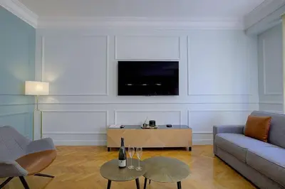 a living room with a couch and a tv on a wall at Luxury apartment in City Center of Nice in Nice