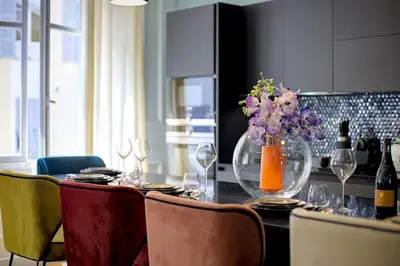 a dining room table with a vase of flowers and wine bottles at Luxury apartment in City Center of Nice in Nice