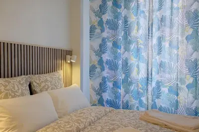 a bedroom with a bed and a blue and white curtain at Luxury apartment in City Center of Nice in Nice