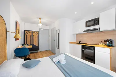 a bedroom with a bed and a kitchen with a table at App-Art in Nice