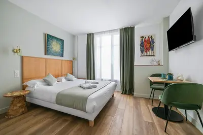 a hotel room with a large bed and a desk at App-Art in Nice