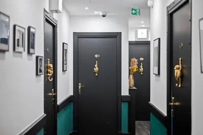a row of black doors in a room with paintings at App-Art in Nice