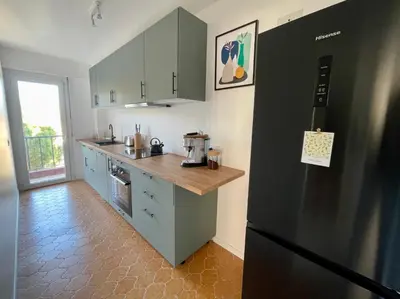a kitchen with a black refrigerator and a counter at Bright appartment with view in Cagnes-sur-Mer