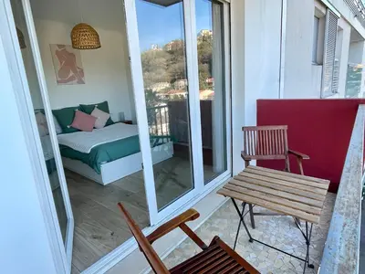 a room with a balcony with a bench and a bed at Bright appartment with view in Cagnes-sur-Mer