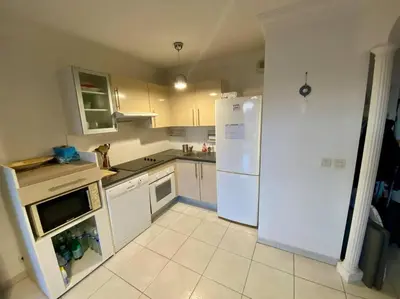 a kitchen with white appliances and a white refrigerator at Nice Ouest St Isidore- 2P au calme in Nice