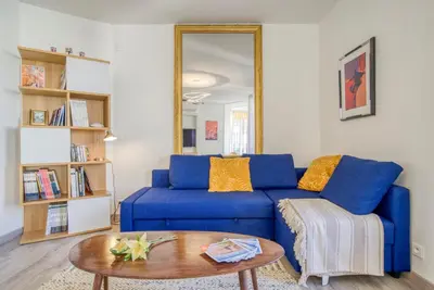 a blue couch in a living room with a table at Sublime, modern, balconies, a/c, refurbished in Nice
