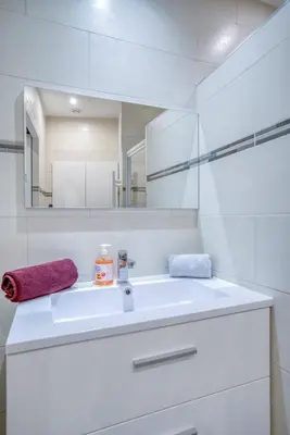 a white bathroom with a sink and a mirror at Sublime, modern, balconies, a/c, refurbished in Nice