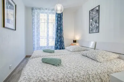 a bedroom with two beds and a window at Sublime, modern, balconies, a/c, refurbished in Nice
