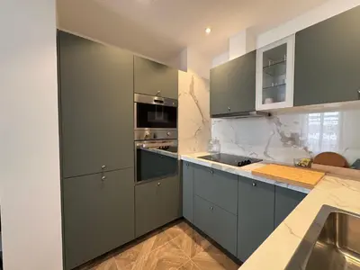 a kitchen with gray cabinets and a stove top oven at Oscar in Nice