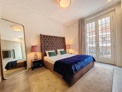 a bedroom with a large bed and a large mirror at Nestor&Jeeves - VICTOIRE - Central - Near Beach in Nice