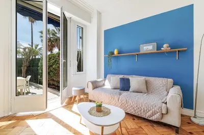 a living room with a couch and a blue wall at Promenade des Anglais 2 Bdr Large Terrace in Nice
