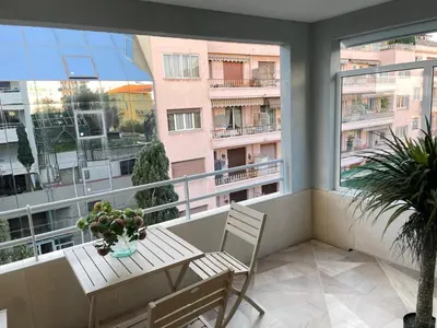 a balcony with a table and chairs on a balcony at STUDIO SUR LA PROMENADE DES ANGLAIS AVEC VUE MER ORIGINALE À 40 m DE LA PLAGE in Nice