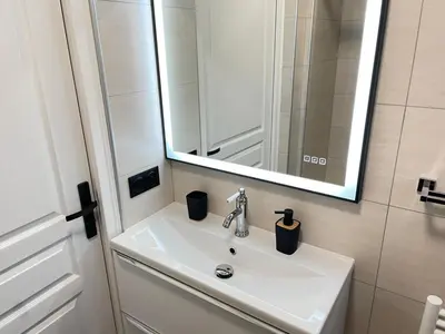 a bathroom with a white sink and a mirror at STUDIO SUR LA PROMENADE DES ANGLAIS AVEC VUE MER ORIGINALE À 40 m DE LA PLAGE in Nice