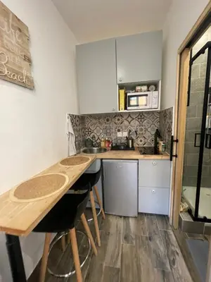 a small kitchen with a table and a microwave at Cosy Home in Villefranche-sur-Mer