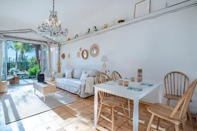 a living room with a white couch and a table at Promenade des Anglais - 2 chambres - Jardin in Nice