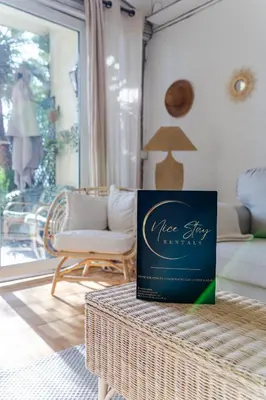 a book sitting on top of a table in a living room at Promenade des Anglais - 2 chambres - Jardin in Nice