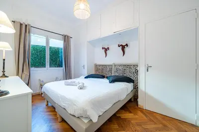 a bedroom with a bed with two teddy bears on it at Promenade des Anglais - 2 chambres - Jardin in Nice