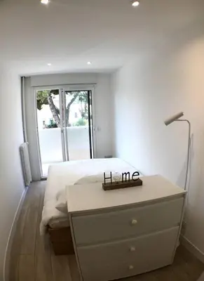 a bedroom with a bed and a dresser with a lamp at Nice bas Cimiez- Coquet F1, climatisée, Parking in Nice