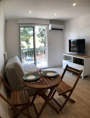 a living room with a table and two chairs at Nice bas Cimiez- Coquet F1, climatisée, Parking in Nice