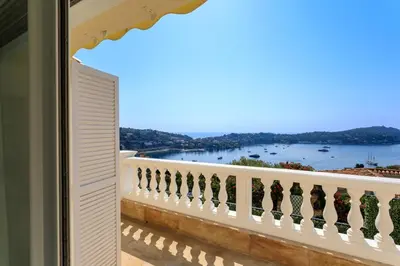 a balcony with a view of the water at VILLA BELLE VUE VI4394 By Riviera Holiday Homes in Villefranche-sur-Mer