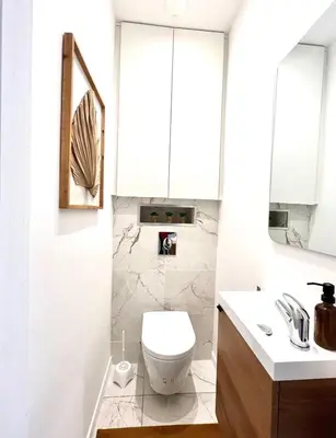a white bathroom with a toilet and a sink at Cœur d'Azur Appartement in Nice
