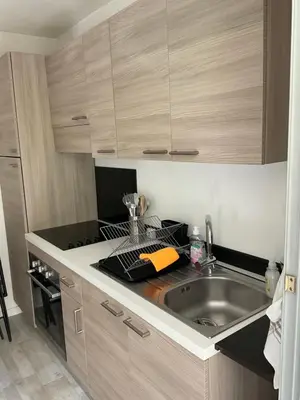 a kitchen with a sink and a counter top at Studio coin nuit terrasse parking Clim in Nice